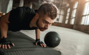 Focused young sportsman doing push ups in gym